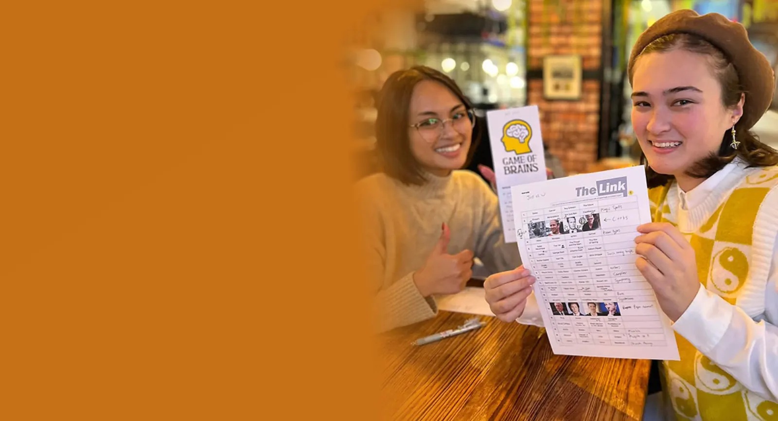 Players with Game of Brains and The Link answer sheets at a quiz night